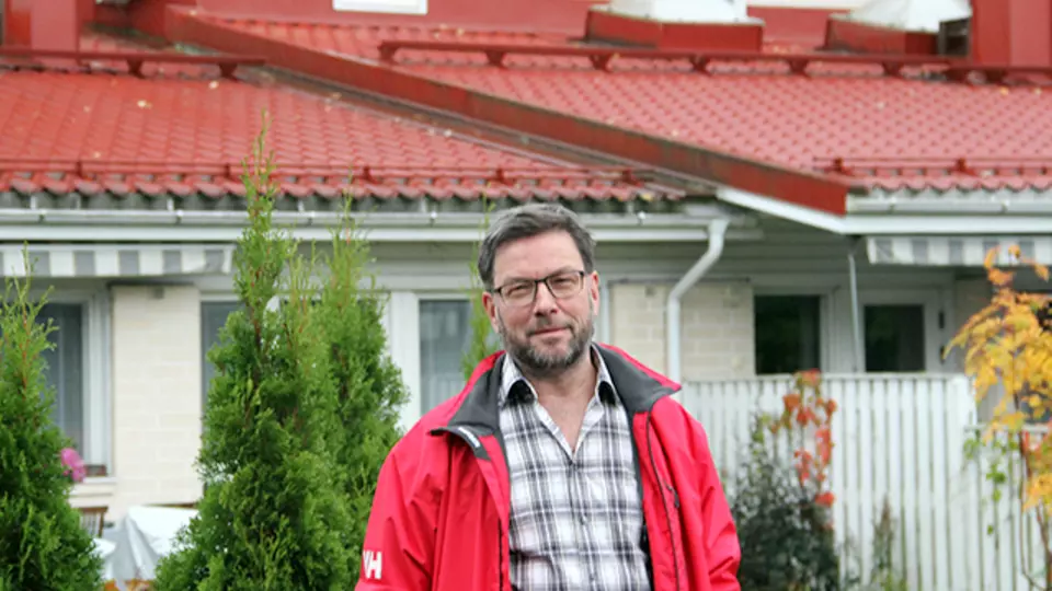 Mikael Träskelin seisoo taloyhtiönsä edessä.